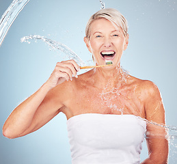 Image showing Woman, studio and toothbrush with water splash, smile or portrait for mouth wellness by blue background. Happy senior model, organic wood brush or dental clean for healthy teeth in self care process