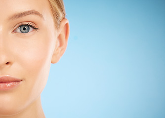 Image showing Skincare, beauty and half portrait of a woman for dermatology isolated on a blue background. Makeup, wellness and face of a model for cosmetics, health and collagen with mockup space on a backdrop