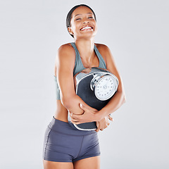 Image showing Diet, weightloss and scale with a black woman athlete in studio on a gray background for body positivity or health. Fitness, weightscale and losing weight with a young female posing for wellness