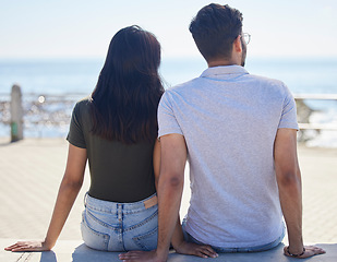 Image showing Beach, view and love with a couple on the promenade together outdoor during summer by the sea or ocean. Back, date and vacation with a man and woman bonding while on holiday by the coast or water