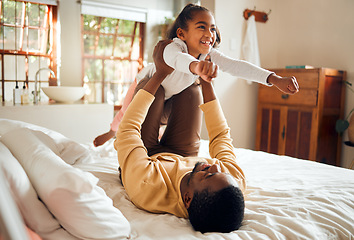 Image showing Happy, fun and dad with child on bed playing, bonding and airplane game for father and daughter time in home. Family, love and playful energy, black man holding girl in air and laughing in bedroom.