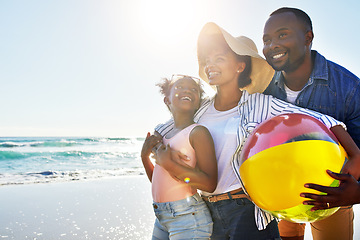 Image showing Black family, kids or beach with a woman, man and girl child carrying a ball while walking on the sand by the sea. Love, nature and ocean with a father, mother and daughter on the coast in summer