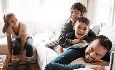 Image showing Happy family, parents and children in a living room at home playing and having fun together in the lounge. Mother, father and kids smiling enjoying and relaxing on the couch or sofa in a house