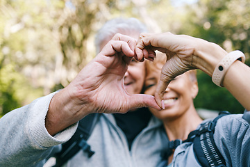 Image showing Heart, love hands and senior couple outdoors on vacation, holiday or hiking trip. Affection sign, romance emoji and elderly interracial couple, man and woman bonding together in nature on a hike.