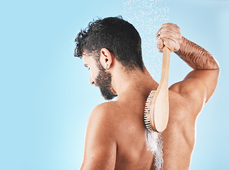 Image showing Shower, man and soap for body cleaning with brush in blue background studio, grooming hygiene and skincare wellness. Model, water and luxury spa body care, dermatology and self care morning routine