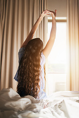 Image showing Morning, wake up and a woman stretching in the bedroom of her home after sleeping or rest on the weekend. Back, bright and flare with a female sitting on a bed while waking with an early stretch