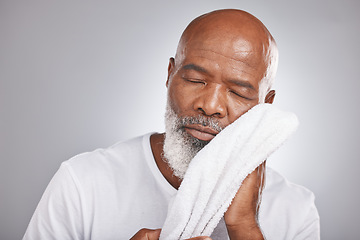 Image showing Skincare, cleaning or old man with a face towel in studio with marketing or mock up space for beauty. Wellness, glowing skin or healthy senior black man grooming with facial cosmetics or product
