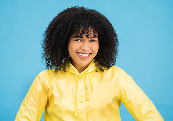 Image showing Black woman, smile and happy in portrait with fashion for winter, rain coat and beauty isolated on blue background. Happiness in studio, style and success with mockup, trendy and female headshot