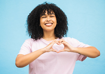 Image showing Heart hand sign, black woman and smile portrait of a young person showing love gesture. African female, happiness and excited space with hands making emoji shape with blue studio background isolated