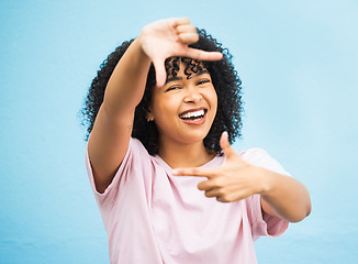 Image showing Black woman, hands and smile for frame, picture perfect or photo against a blue studio background. Portrait of African American female, person or lady model smiling showing finger sign in photography