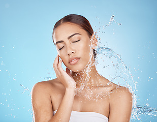 Image showing Woman hand, water splash or face skincare on blue background studio in healthcare wellness, relax hygiene or dermatology grooming. Beauty model, wet shower or water drop in facial cleaning or touch