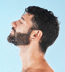 Image showing Shower, man with water and face profile with cleaning and hygiene, grooming and skincare against blue studio background. Clean with water drops, facial with natural treatment and cosmetic mockup