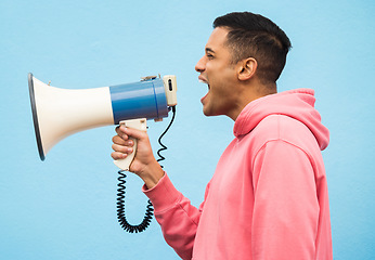 Image showing Man, speaker and megaphone in studio for justice, microphone speech and communication in blue background. Male shouting, protest announcement and audio information with voice broadcast for change