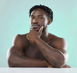 Image showing Confident, handsome and portrait of a young black man isolated on a blue background in studio. Sexy, skincare and healthy body of an African model with muscle, confidence and seduction on a backdrop