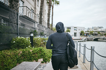 Image showing Fitness, hoodie or man walking to gym for body training, exercise or workout with a duffle bag in Miami, Florida. City, mindset or healthy sports athlete with wellness goals, motivation or mission