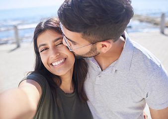 Image showing Couple, love and selfie at the beach, travel and kiss by ocean with support, trust and care with adventure in Mumbai. Smile in picture, happy and memory with smartphone photography for romance