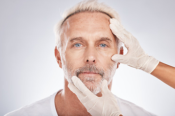 Image showing Man face, hands or cosmetic surgery gloves on studio background for skincare collagen, medical dermatology or anti aging grooming. Portrait, plastic surgeon or mature patient check for facial change