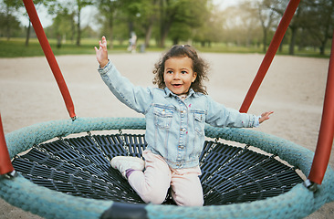 Image showing Play in playground, girl child in park with outdoor fun, early childhood development with toddler on trampoline. Kid, freedom and energy, playful and playing during holiday and growth in nature