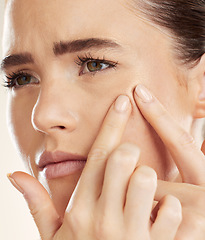 Image showing Face, hands and pimple with a woman checking or examining her skin for acne problems in studio. Facial, fingers and breakout with an attractive young female indoor to squeeze or pop a blackhead