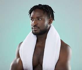 Image showing Wellness, grooming and black man thinking of a shower, cleaning and isolated on a blue background. Beauty, health and African model with a towel for cosmetic morning routine on a studio backdrop