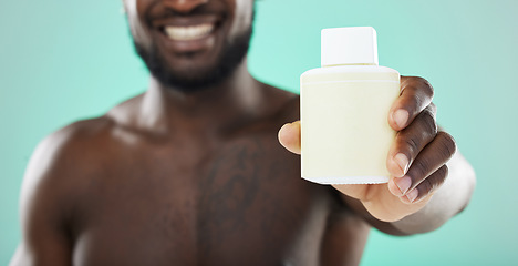Image showing Black man, hands and skincare cosmetics, product or serum bottle for facial or body treatment against studio background. Hand of African American male holding solution for skin, advertising or brand