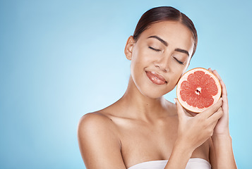 Image showing Skincare, grapefruit and happy wellness woman satisfied with vitamin c body care glow treatment. Aesthetic, detox and natural cosmetic model in blue studio with beauty marketing mockup.