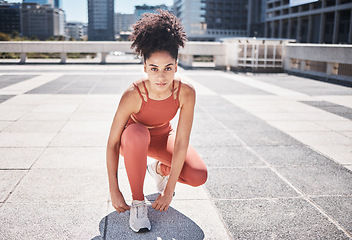 Image showing Portrait, fitness and black woman tie shoes getting ready for training in city. Face, sports and female runner tying sneaker lace and preparing for workout jog, running or exercise outdoors on street