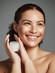 Image showing Wellness, aesthetic and facial cream of black woman with healthy beauty glow and natural freckles. Thinking skincare girl with smile and luxury face lotion product on gray studio background.