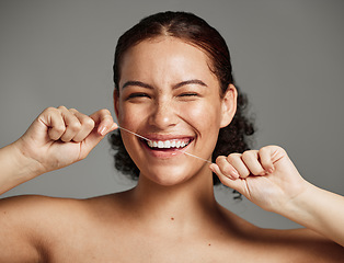 Image showing Dental floss, flossing teeth and woman with a smile for oral hygiene, health and wellness on studio background. Face of a happy female during self care, healthcare and grooming for a healthy mouth