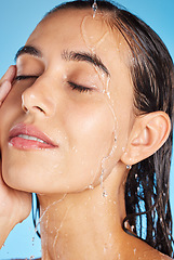 Image showing Woman, shower water and face for beauty, skincare and peace with blue studio background. Calm, relax and healthy young person doing morning self face for skin glow with clean beauty treatment