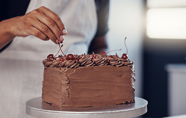 Image showing Hand, cake and food with a man chef working in a kitchen while preparing dessert for a party celebration. Cooking, chocolate and cherries with a male at work in a bakery to make gourmet confectionary