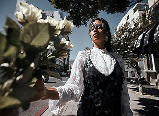 Image showing Fashion, young woman in city with rose, nature and urban designer clothes, glamour and creative with art in street. Trendy, natural beauty and bouquet, summer with stylish model, cosmetic and sparkle