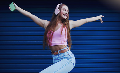 Image showing Woman, headphones and dancing outdoor for celebration, achievement and streaming music for fun. Young female, lady or headset for radio, listen to audio or songs with confident girl and casual outfit