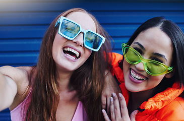 Image showing Selfie, gen z and portrait of fun women in the city with fashion, sunglasses and happy in Korea. Smile, stylish and face of friends with a photo, streaming and crazy on a blue wall with style