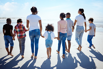 Image showing Big family, beach walk and summer for holiday, sunshine and bonding with interracial diversity by water. Happy family, lesbian mom and holding hands for solidarity, care and love on vacation by sea