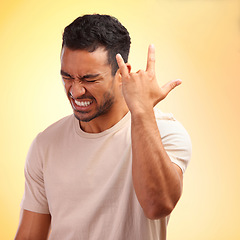 Image showing Happy, confident and Asian man with hand for rock isolated on a yellow studio background. Condidence, music and person with a gesture sign for fun, metal sound and audio on a bright backdrop