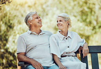 Image showing Love, retirement and couple on bench in park with smile, relax and bonding time in nature together. Romance, senior man and retired woman sitting in garden, happy people and romantic summer weekend.