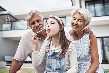 Image showing Smile, family and girl with bubbles and grandparents enjoying weekend, holiday and quality time together. Love, home and happy girl, grandmother and grandfather bonding, relaxing and fun in garden