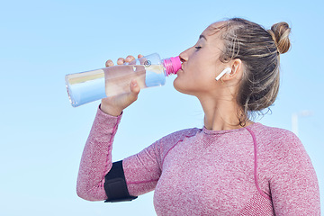 Image showing Woman runner, water bottle and music with earphones for focus, workout and outdoor training for health. Girl, wellness and hydration for running, exercise or streaming audio in summer for strong body