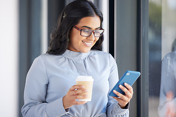 Image showing Coffee, phone and business woman on a break in the office networking on social media, mobile app or internet. Happy, smile and professional employee reading a blog on her cellphone in the workplace.