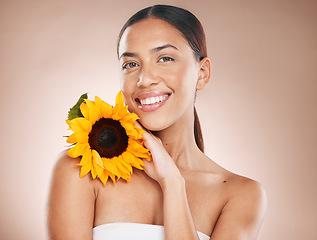 Image showing Beauty, skincare and flower with portrait of woman for natural, cosmetics and organic facial product. Spring, sunflower and smile with face of girl model for self care, luxury and wellness in studio