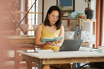 Image showing Startup, Asian or business woman reading book for research, knowledge or notebook for creative idea. Focus, thinking or girl with notes and laptop for planning social media, innovation or B2B review