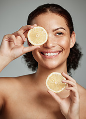 Image showing Face, skincare and woman with lemon in studio isolated on a gray background. Fruit, organic cosmetics and happy female model holding lemons for healthy diet, vitamin c or minerals, wellness or beauty