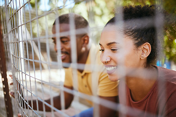 Image showing Happy couple, fence and smile at animal shelter, pet centre or zoo looking for a cute companion to adopt. Black man and woman smiling in happiness behind fencing for adorable fluffy pups for adoption