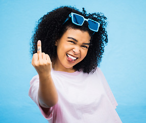 Image showing Portrait, middle finger and hand, emoji and black woman in studio, rude and carefree on a blue background. Face, rebel and hands by girl for message, attitude and expression, personality and isolated