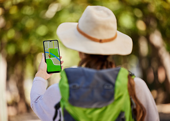 Image showing GPS, direction and woman hiking in a forest for exercise, adventure or wellness in nature. Navigation app, phone and female hiker trekking on an outdoor trail in the woods alone with a mobile map.