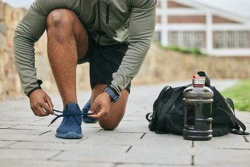 Image showing Fitness, sports shoes and black man tie before outdoor cardio exercise or workout in the park. Sport, runner and African male athlete preparing for endurance training for race, challenge or marathon.