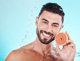 Image showing Skincare, water splash and portrait of man with grapefruit on blue background for vitamin c detox for healthy skin and smile. Fruit, water and facial wellness, spacleaning and happy male model face