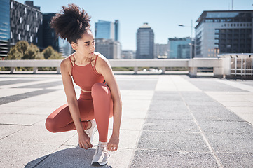 Image showing Sports, fitness and black woman tie shoes getting ready for training in city. Face, thinking and female runner tying sneaker lace and preparing for workout jog, running or exercise outdoors on street