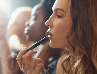 Image showing Makeup, lipstick and woman in bathroom of nightclub, gen z friends getting ready for party or music concert. Cosmetics, diversity and women backstage at theater, fashion show or dark night club.